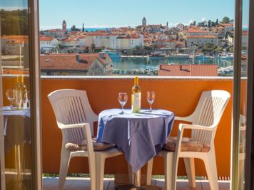 gelbe Wohnung, Balkon mit Blick auf das Meer und die Stadt Rab, Tisch und Stühle